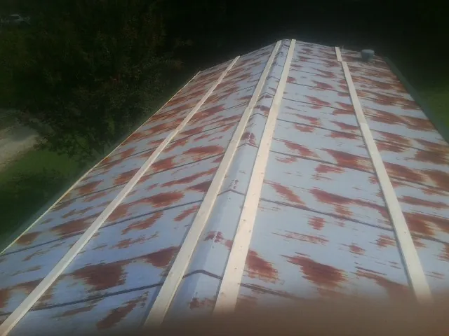 Rusted metal roof panels with new wood purlins before replacement — Storm Damage Roof Repair in Iron City by Roofing Brothers