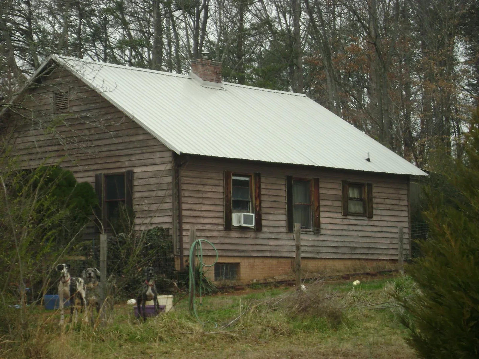 White metal roof on an old wood sided farmhouse, from a Metal Roof Installation job in Iron City
